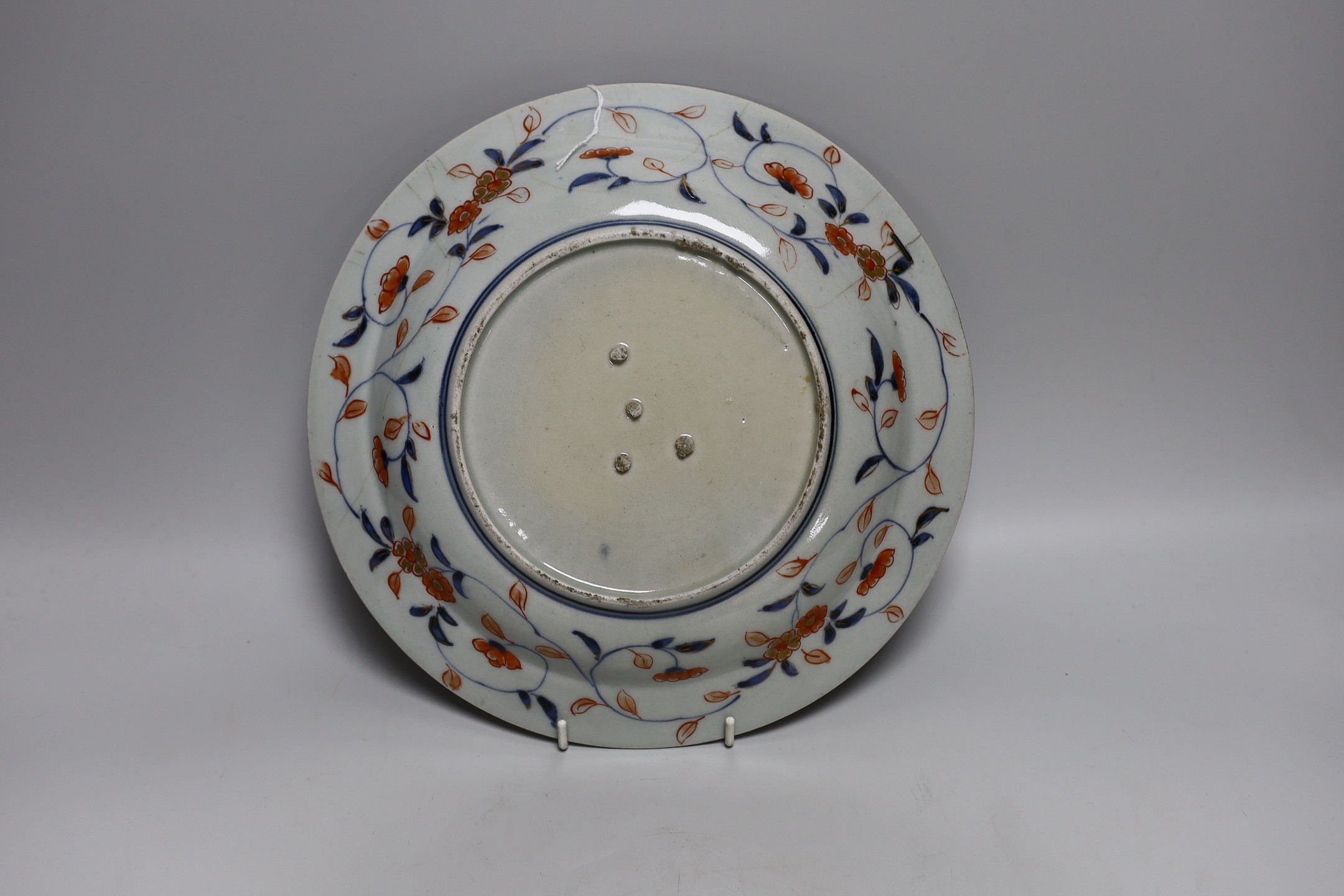 A Japanese Arita dish, late 17th century, painted in Imari palette, stilt marks, cracked, 28cms diameter